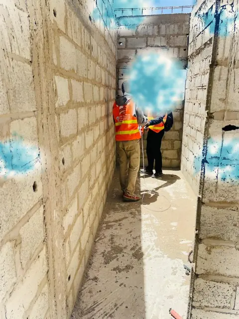 Couloir entre deux murs de parpaings en construction