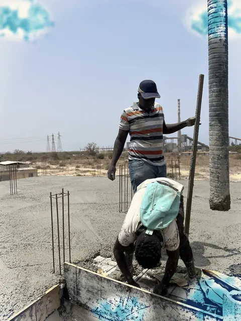 Ouvriers qui coulent du béton sur une dalle