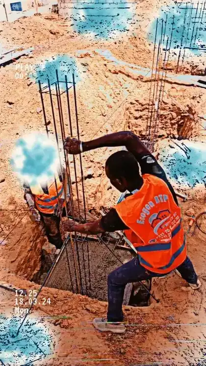 Ferraillage d'une fondation avec des ouvriers dans la fouille