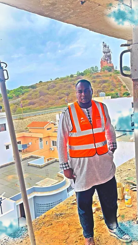 Un responsable en gilet orange avec la colline en arrière-plan