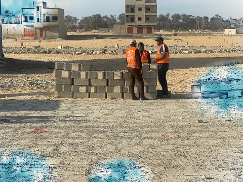 Terrain de chantier, équipe devant des parpaings