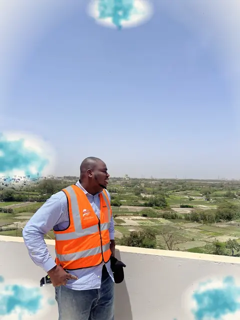 Un responsable en gilet regarde le terrain depuis une terrasse