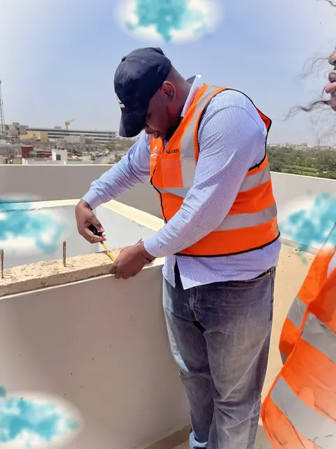 Mesure sur un muret de terrasse par un technicien en gilet